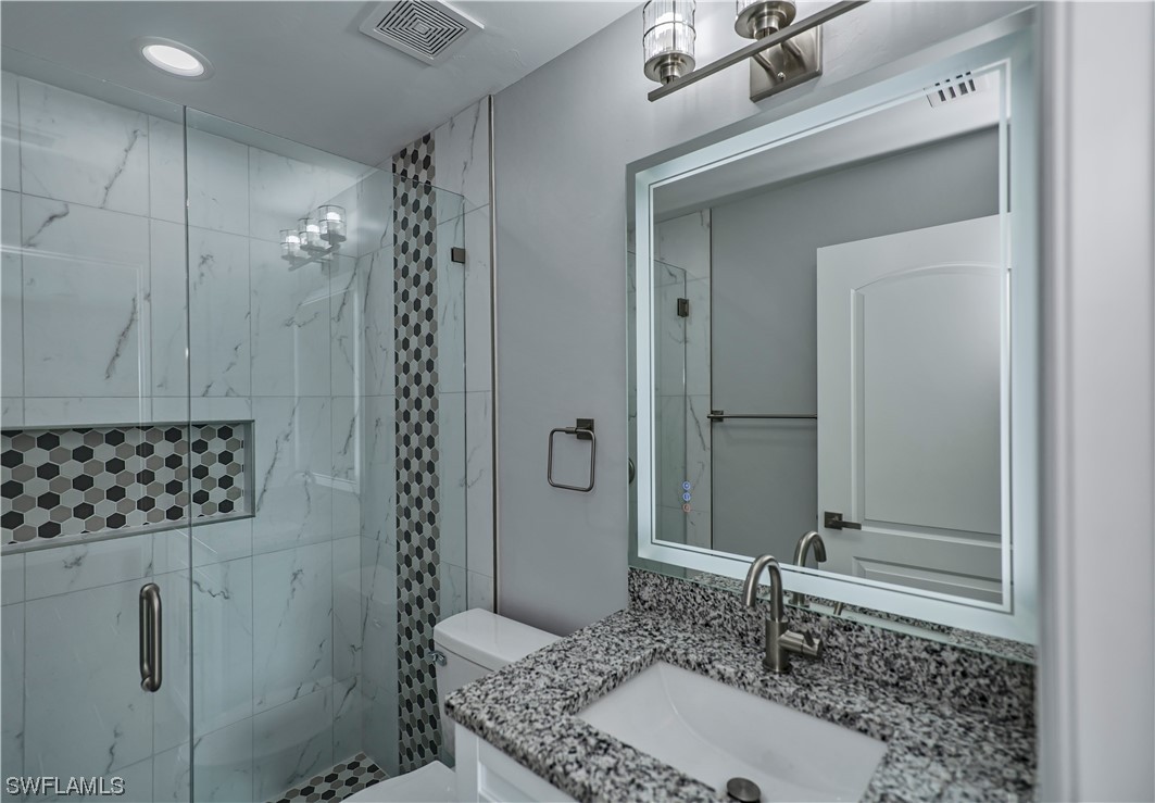 9024 Largo Circle LaBelle, FL 33935 - Photo 20 of 27 a bathroom with a granite countertop sink a mirror and shower