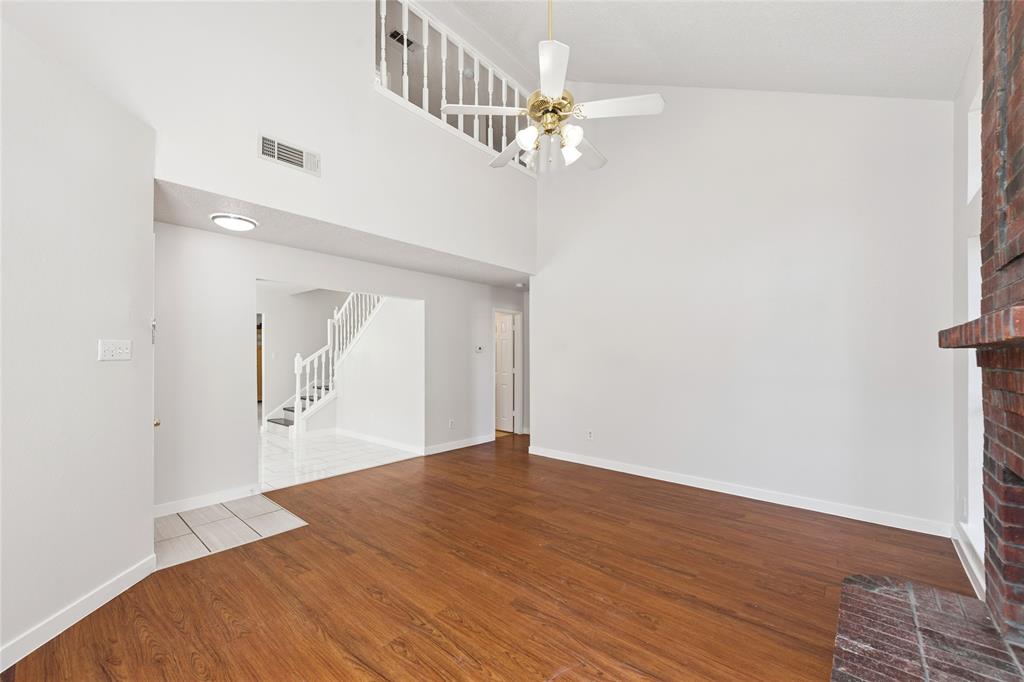 3721 Smartt Street Rowlett, TX 75088 - Photo 4 of 25 Unfurnished living room with wood finished floors, stairway, high vaulted ceiling, and a ceiling fan