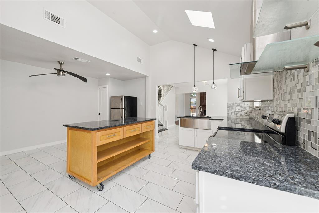 3721 Smartt Street Rowlett, TX 75088 - Photo 10 of 25 Kitchen featuring open shelves, dark stone countertops, stainless steel appliances, backsplash, and hanging light fixtures