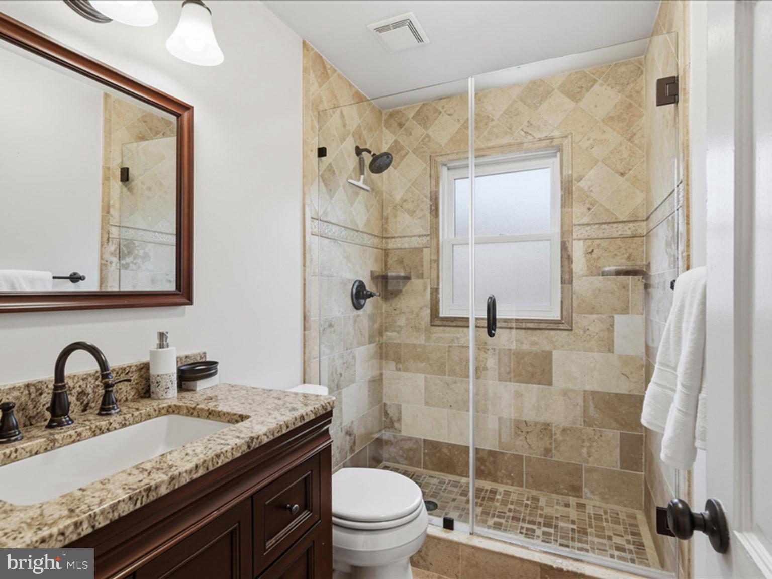 6437 Spring Terrace Falls Church, VA 22042 - Photo 15 of 42 a bathroom with a granite countertop sink toilet and shower