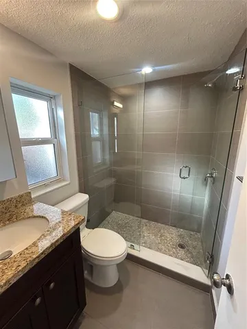 a bathroom with a granite countertop sink toilet and shower