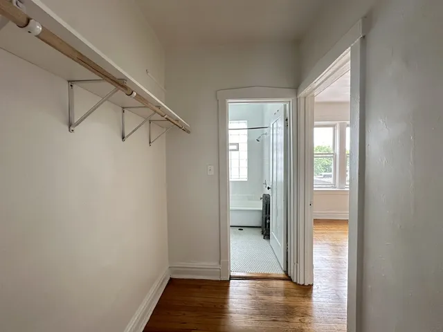 a view of a room with wooden floor a bathroom and a sink