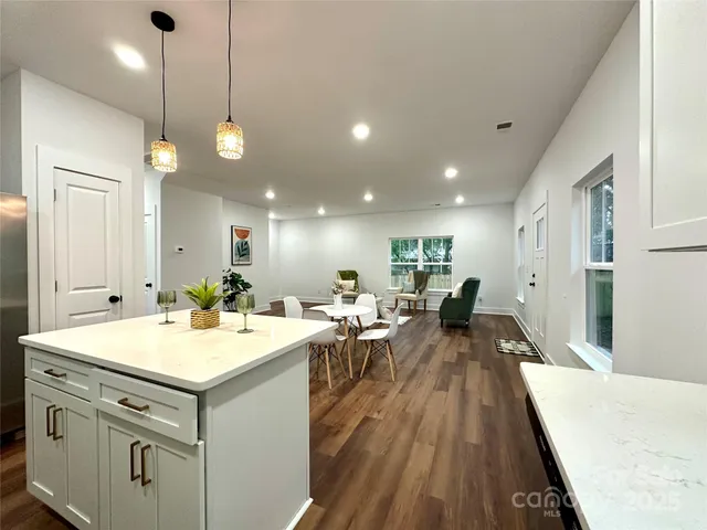a large kitchen with kitchen island a large island in the center and stainless steel appliances