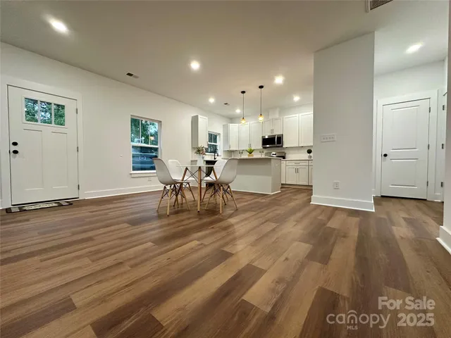 a view of kitchen dining table chairs and refrigerator