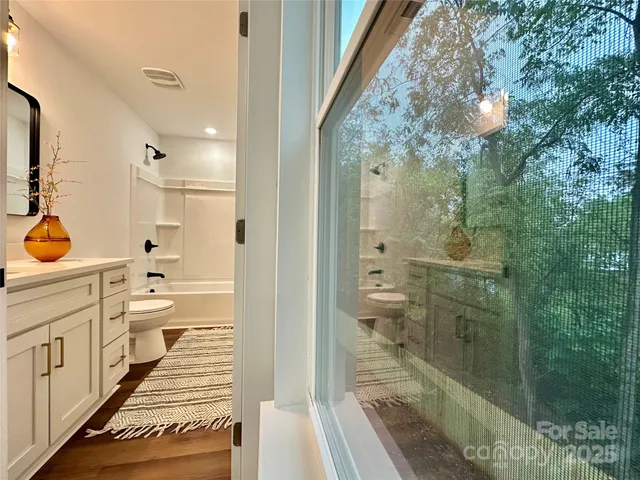 a bathroom with a sink toilet a mirror and shower