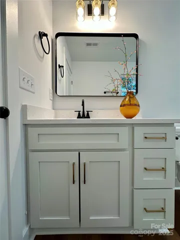 a bathroom with a sink vanity and mirror