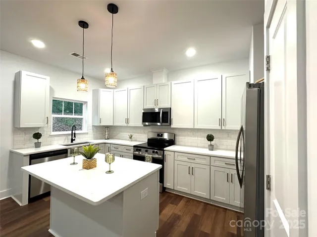 a kitchen that has a sink a microwave a stove and a window