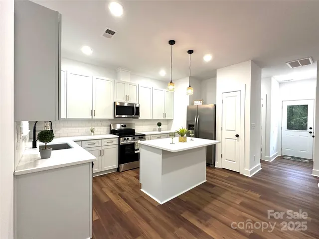 a kitchen with a sink cabinets and wooden floor