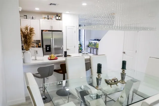 a dining room with furniture a large window and wood floor