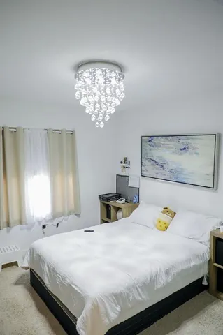 a bedroom with a bed and a chandelier