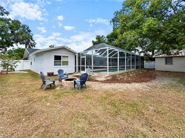 a view of a backyard with a sitting area and wooden fence