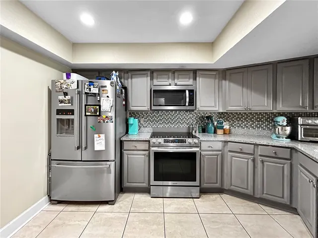 a kitchen with stainless steel appliances granite countertop a refrigerator and a sink