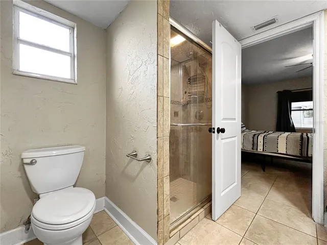 a bathroom with a toilet and a shower