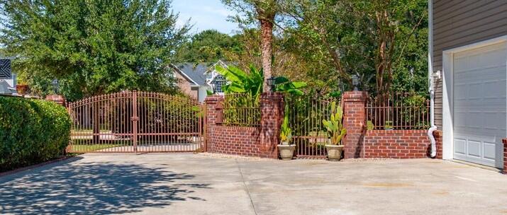 213 Harlech Way Charleston, SC 29414 - Photo 7 of 69 Driveway with iron gates and brick walls