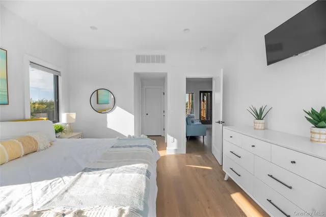 a bedroom with a bed and a potted plant