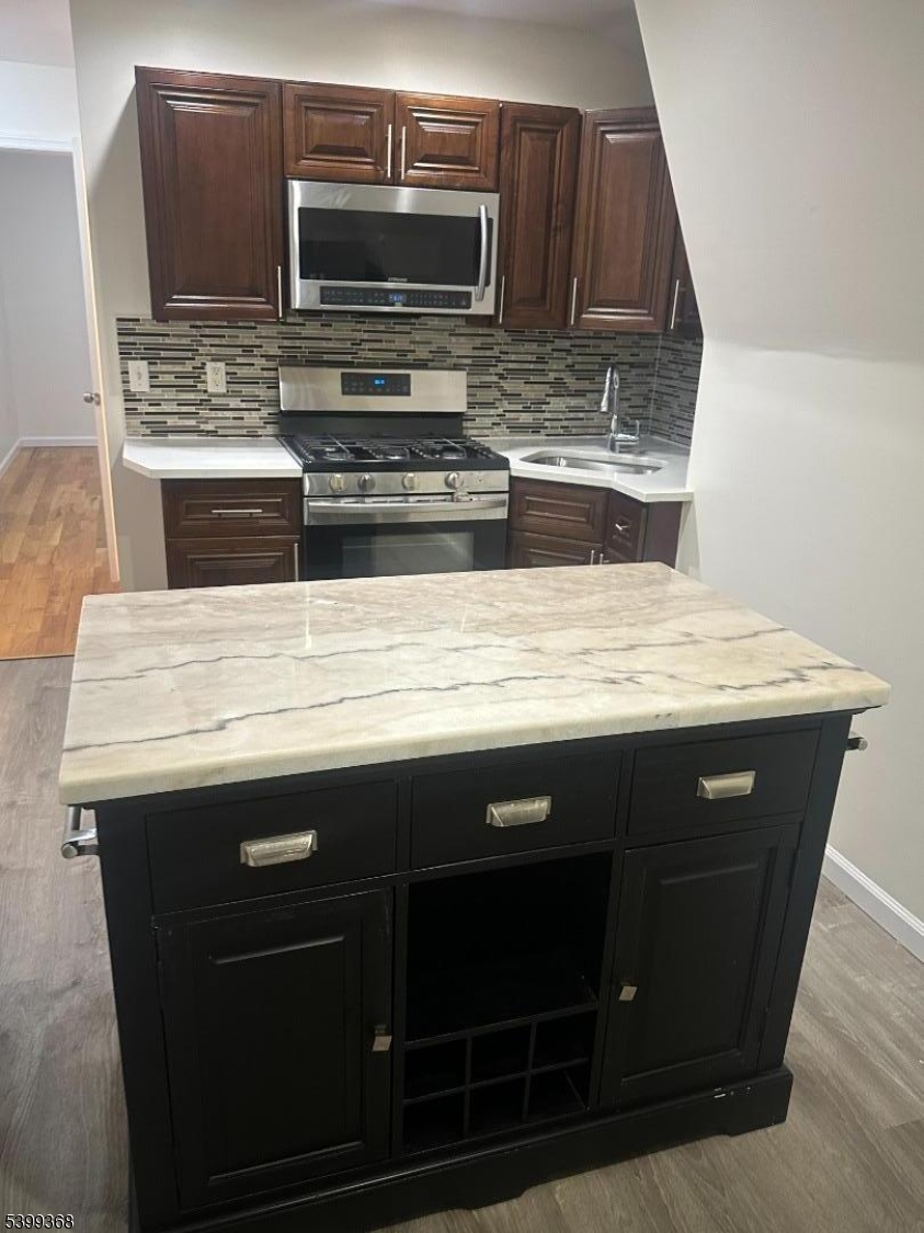 192 Fairview Avenue, Unit 3 Jersey City, NJ 07304 - Photo 7 of 9 a view of kitchen island microwave stove and oven