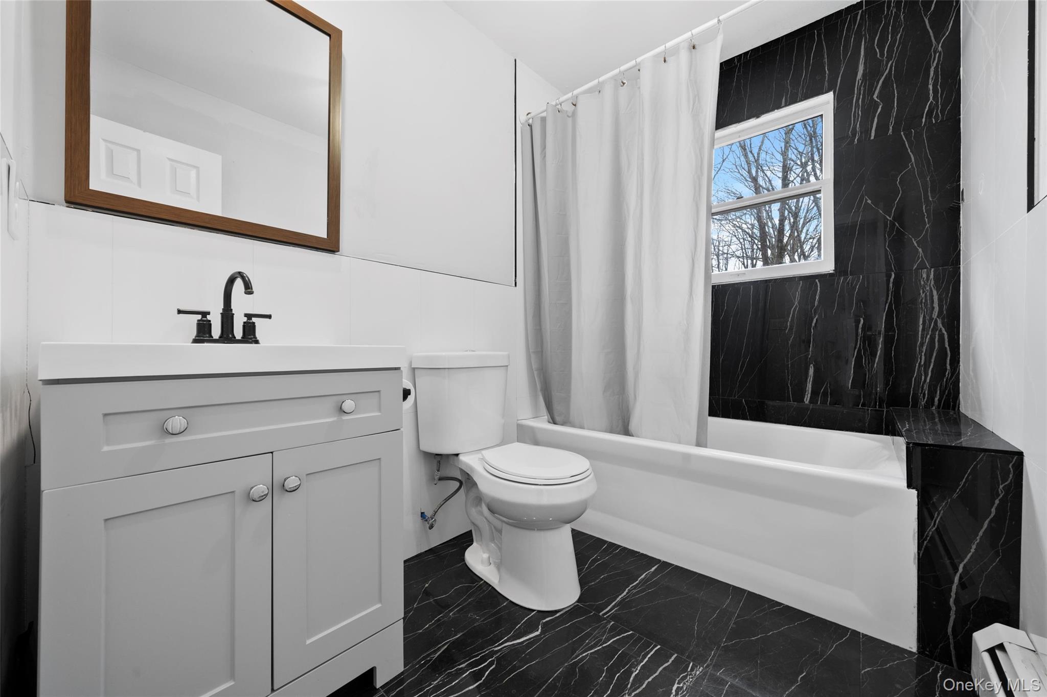 57 School Road Monroe, NY 10950 - Photo 25 of 33 a bathroom with a toilet a sink and a window