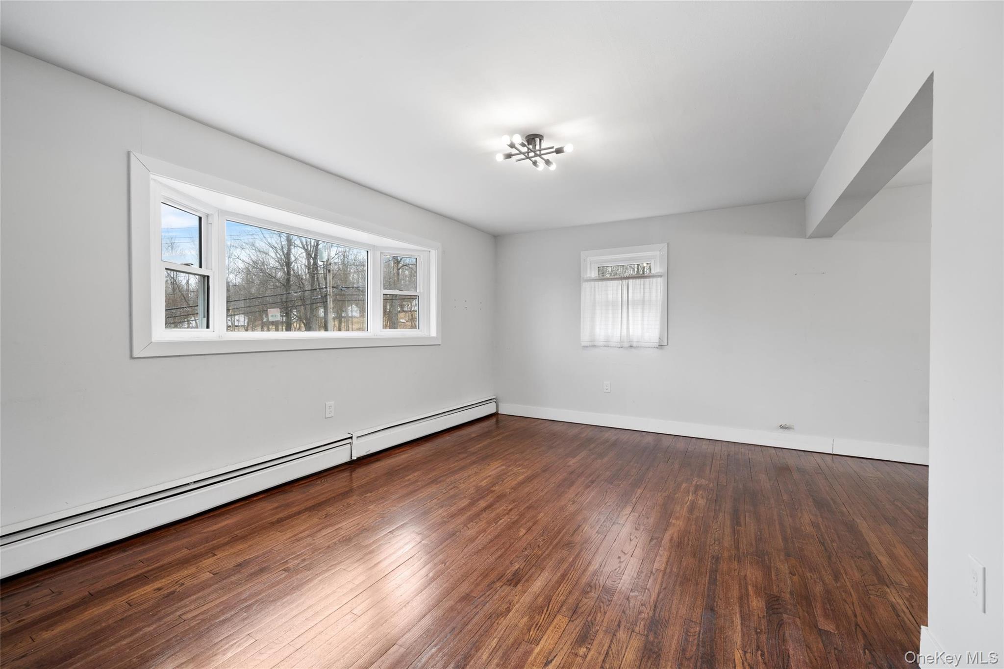 57 School Road Monroe, NY 10950 - Photo 3 of 33 a view of an empty room with wooden floor and a window