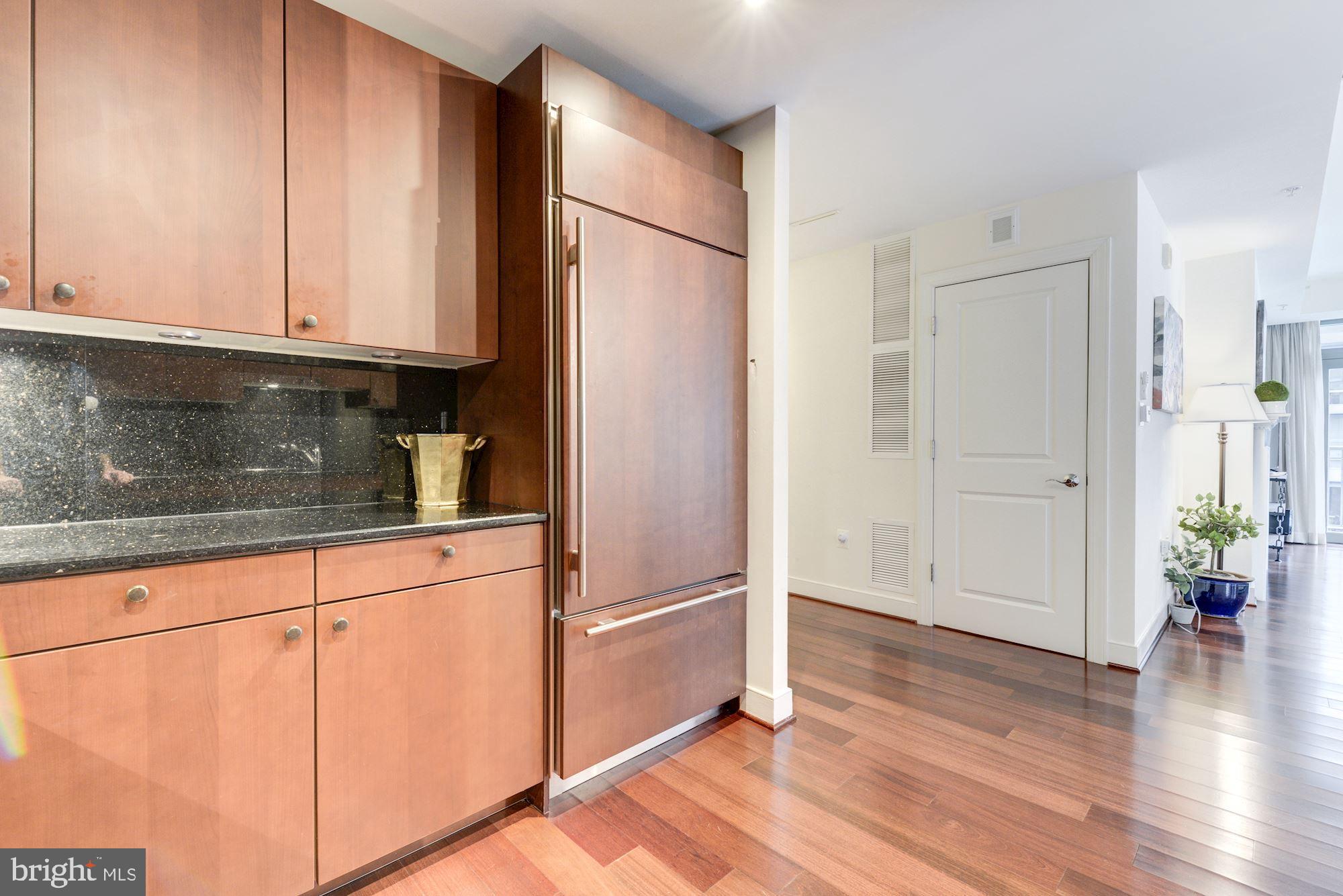 2425 L Street Northwest, Unit 539 Washington, DC 20037 - Photo 11 of 31 a kitchen with granite countertop wooden cabinets and a stainless steel appliances