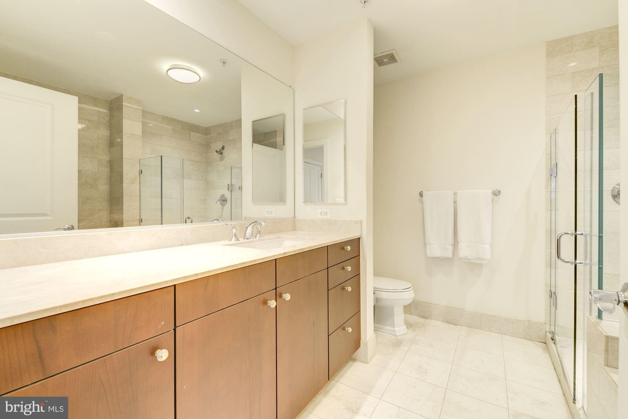 2425 L Street Northwest, Unit 539 Washington, DC 20037 - Photo 18 of 31 a bathroom with a double vanity sink toilet and shower