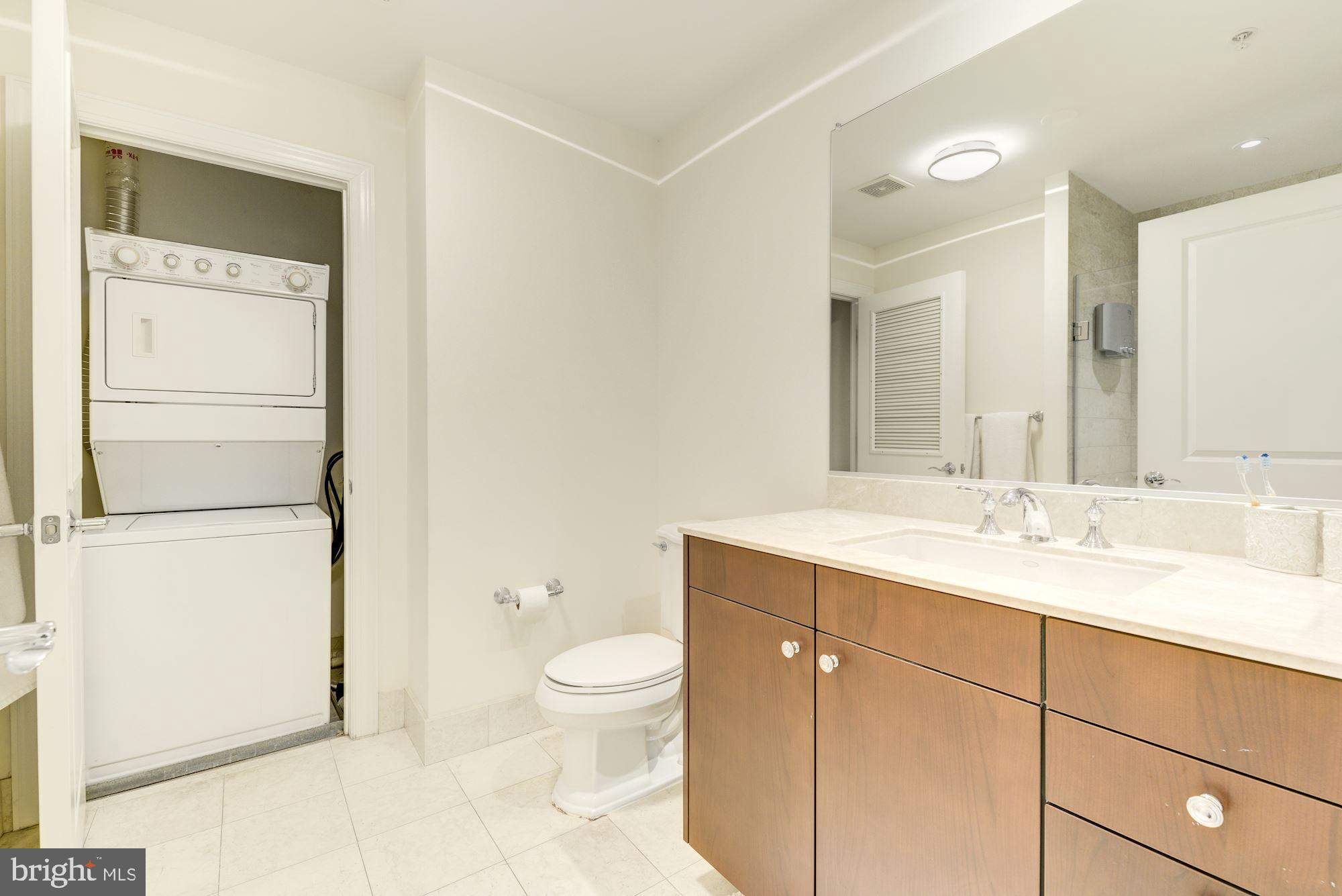 2425 L Street Northwest, Unit 539 Washington, DC 20037 - Photo 20 of 31 a bathroom with a granite countertop sink toilet and mirror