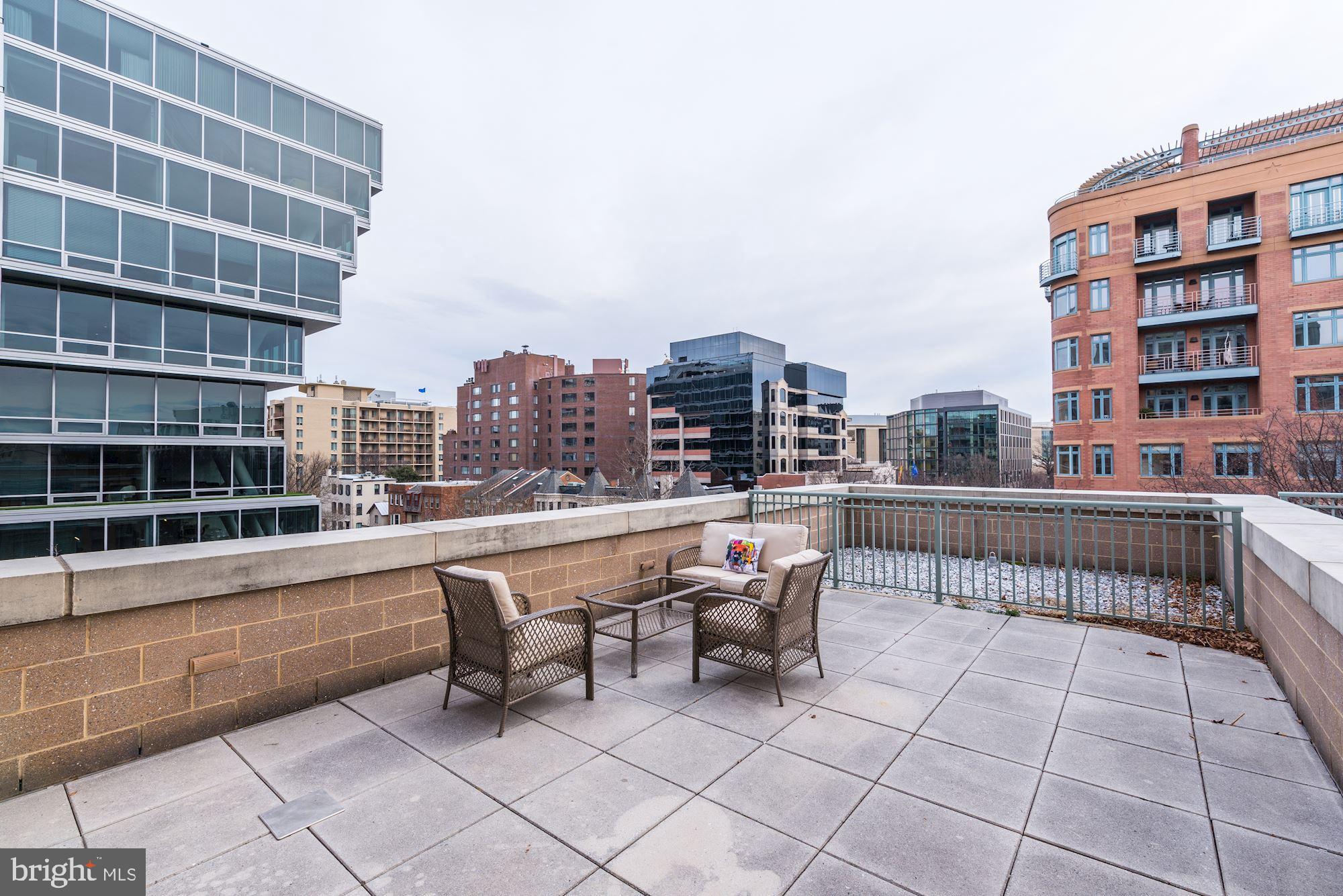 2425 L Street Northwest, Unit 539 Washington, DC 20037 - Photo 6 of 31 a roof deck with table and chairs and potted plants