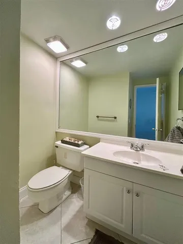 a bathroom with a sink and mirror with toilet