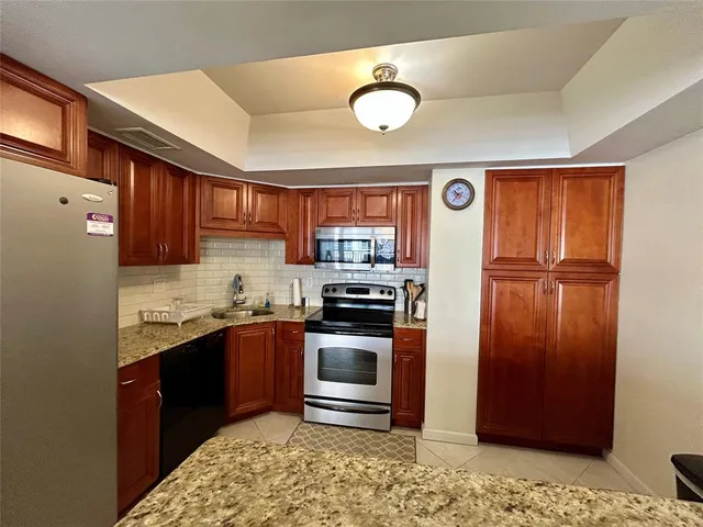 a kitchen with granite countertop stainless steel appliances and wooden cabinets