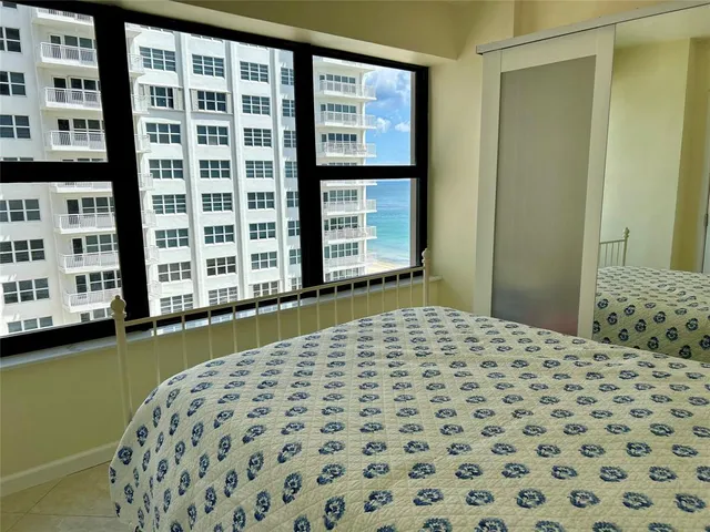 a bedroom with a bed and a large window