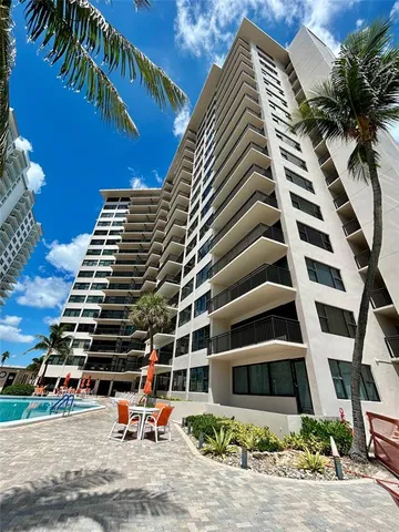a view of swimming pool with outdoor seating and palm trees