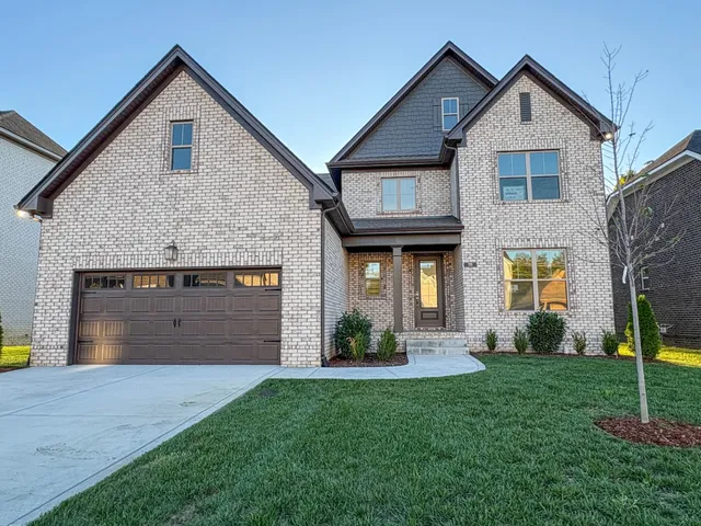a front view of a house with a yard and garage