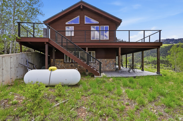 6 Beaver Springs Rancheros Oakley, UT 84055 - Photo 66 of 68 Wood-sided residence featuring a stone foundation and a large elevated deck with contemporary railings