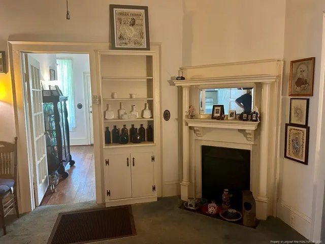 a view of a livingroom with a fireplace cabinet and window
