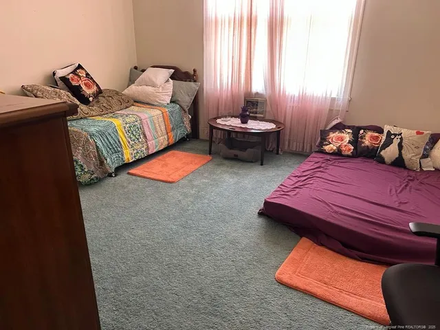 a bedroom with two beds and a lamp