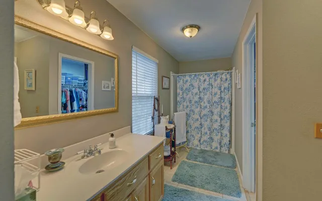 a bathroom with a sink a toilet a mirror and shower