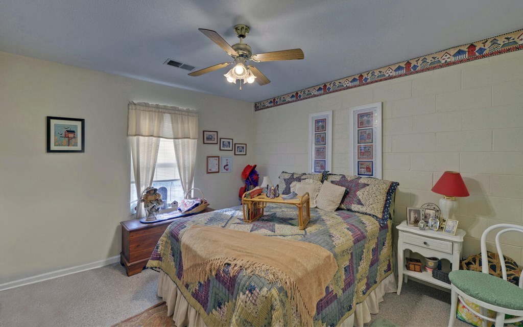 7300 Mr Bert Road Hiawassee, GA 30546 - Photo 32 of 48 a bedroom with a bed and a chandelier