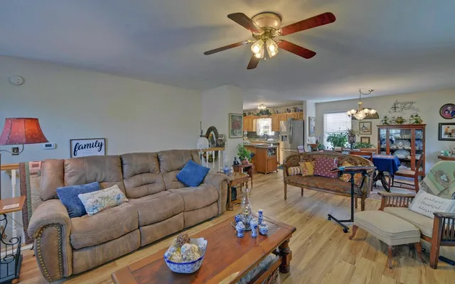 a living room with furniture a chandelier and a dining table