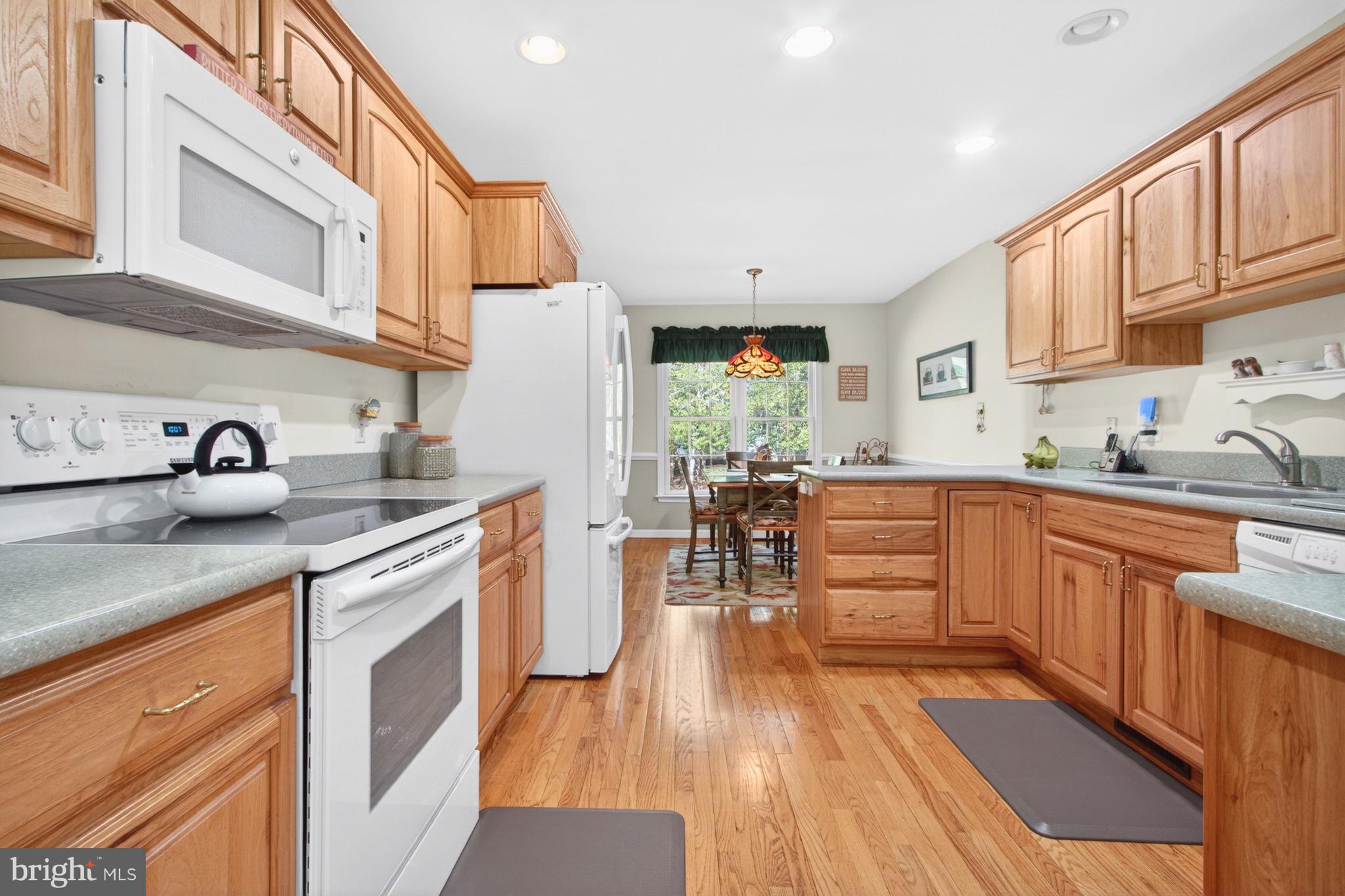 34371 Owls Nest Road Lewes, DE 19958 - Photo 11 of 58 a kitchen with stainless steel appliances a stove a sink dishwasher and cabinets with wooden floor