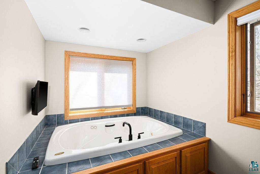 4856 Kingston Street Duluth, MN 55804 - Photo 35 of 88 Built-in jetted tub surrounded by blue tile and wood-finish cabinetry