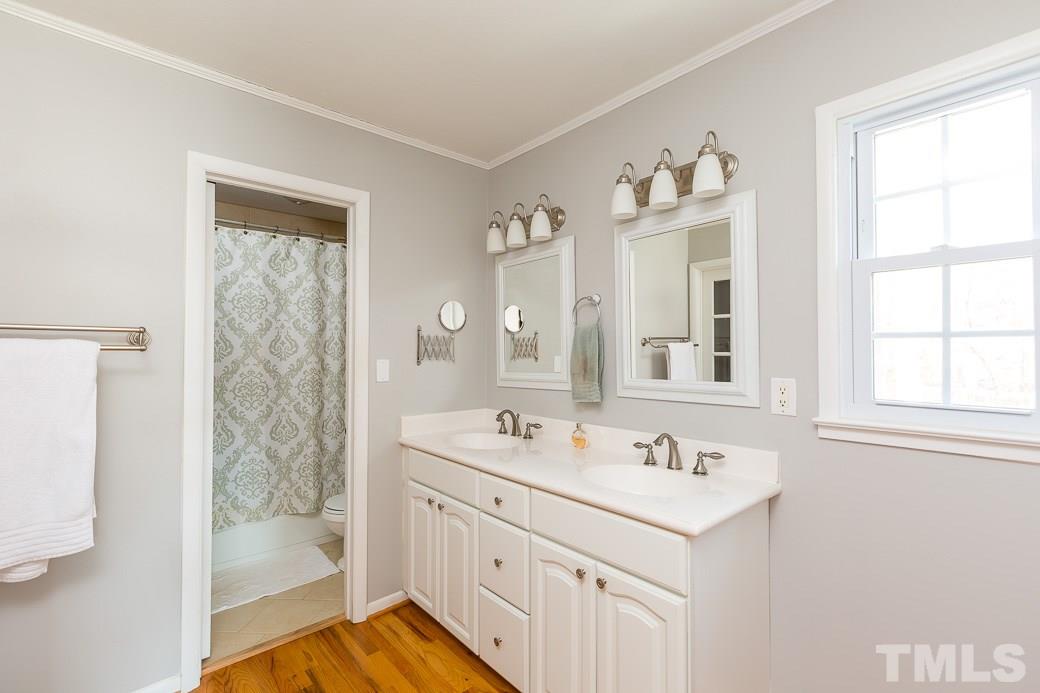 7404 Fiesta Way Raleigh, NC 27615 - Photo 8 of 11 a bathroom with a sink a mirror and a shower