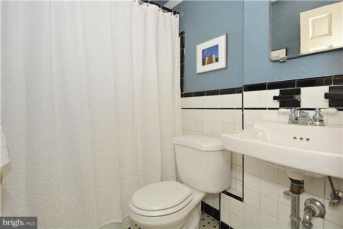 1208 Portner Road Alexandria, VA 22314 - Photo 20 of 30 a bathroom with a toilet a sink and a mirror