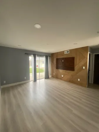an empty room with a window and a fan