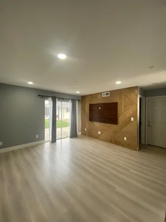 an empty room with windows and fan