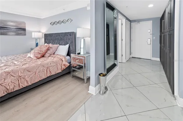 a bedroom with a bed and a refrigerator