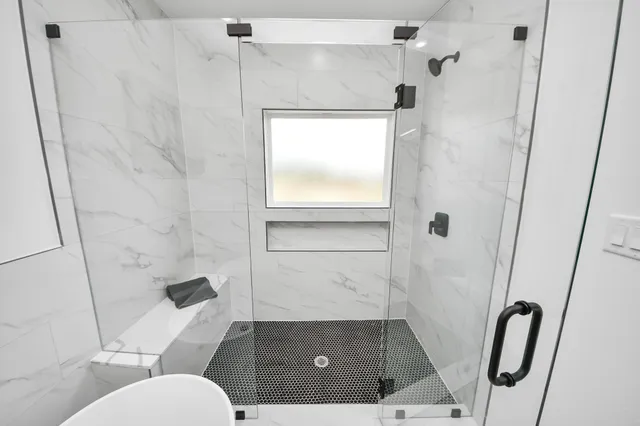 a bathroom with a toilet and a shower