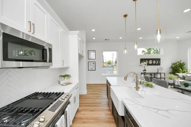 a kitchen with stainless steel appliances kitchen island granite countertop a stove a sink and a microwave
