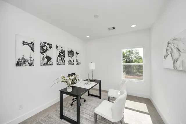 a view of a workspace with furniture and a window