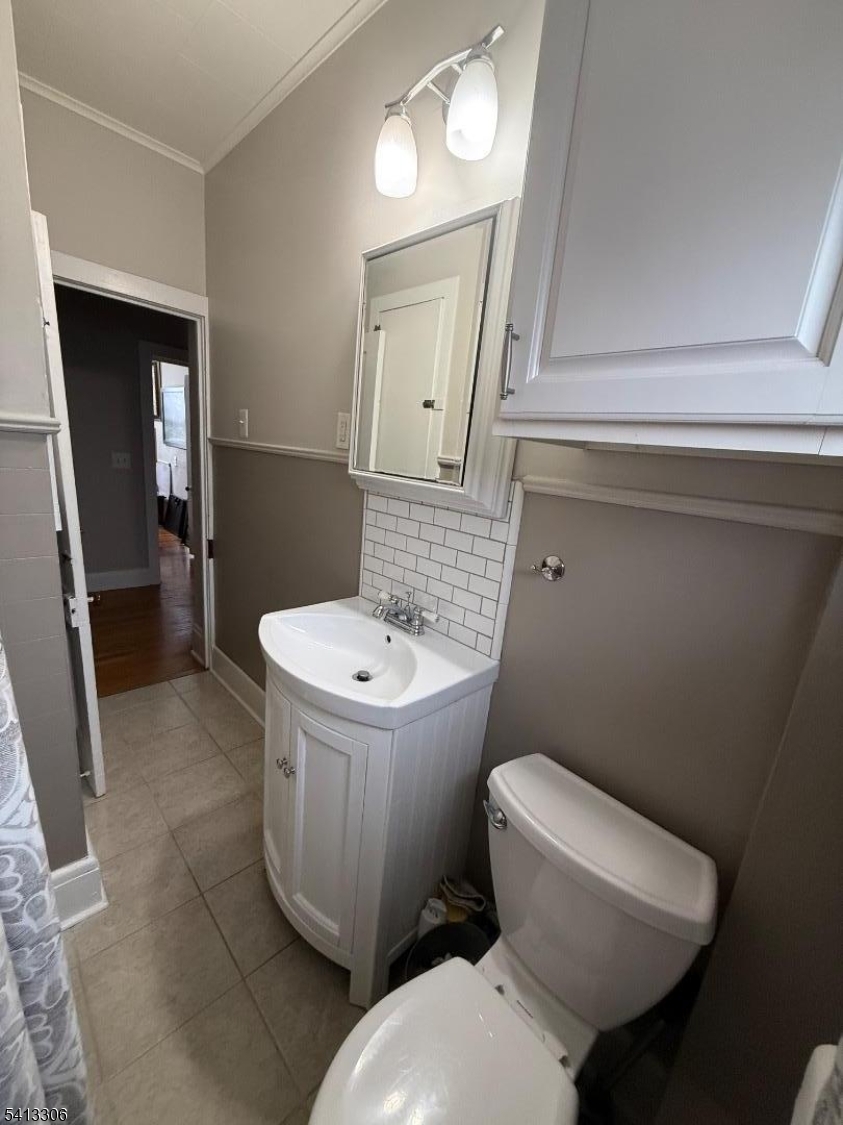 69 2nd Avenue Raritan, NJ 08869 - Photo 11 of 12 a white toilet sitting next to a bathroom sink and a mirror
