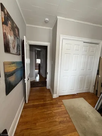 a view of a hallway with wooden floor and staircase