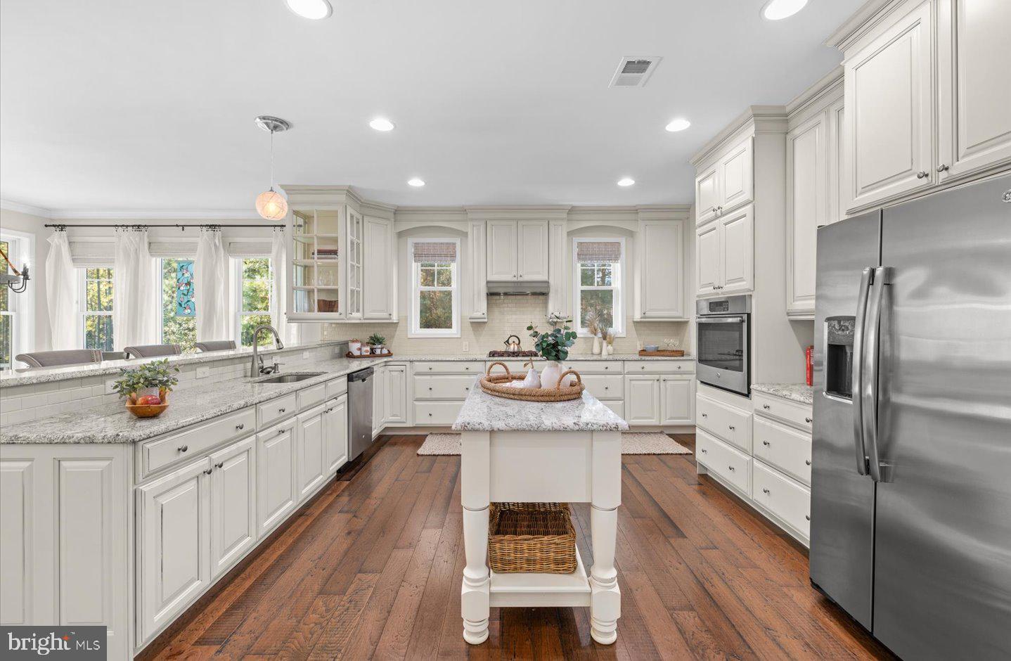 23280 Horse Island Road Lewes, DE 19958 - Photo 16 of 71 a large kitchen with stainless steel appliances kitchen island granite countertop a lot of counter space and wooden floors